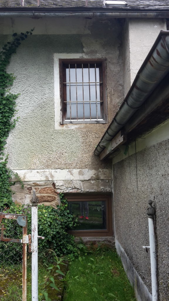 Kikis Haus. Oben sieht man das Badezimmer/WC-Fenster und unten das (reparierte) Kellerfenster
