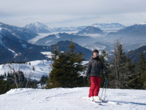 Kiki steht mit Skiern am Berg
